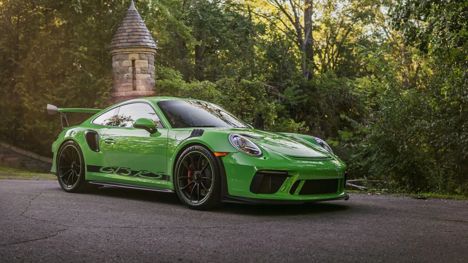 Porsche 911 GT3 verte devant une église