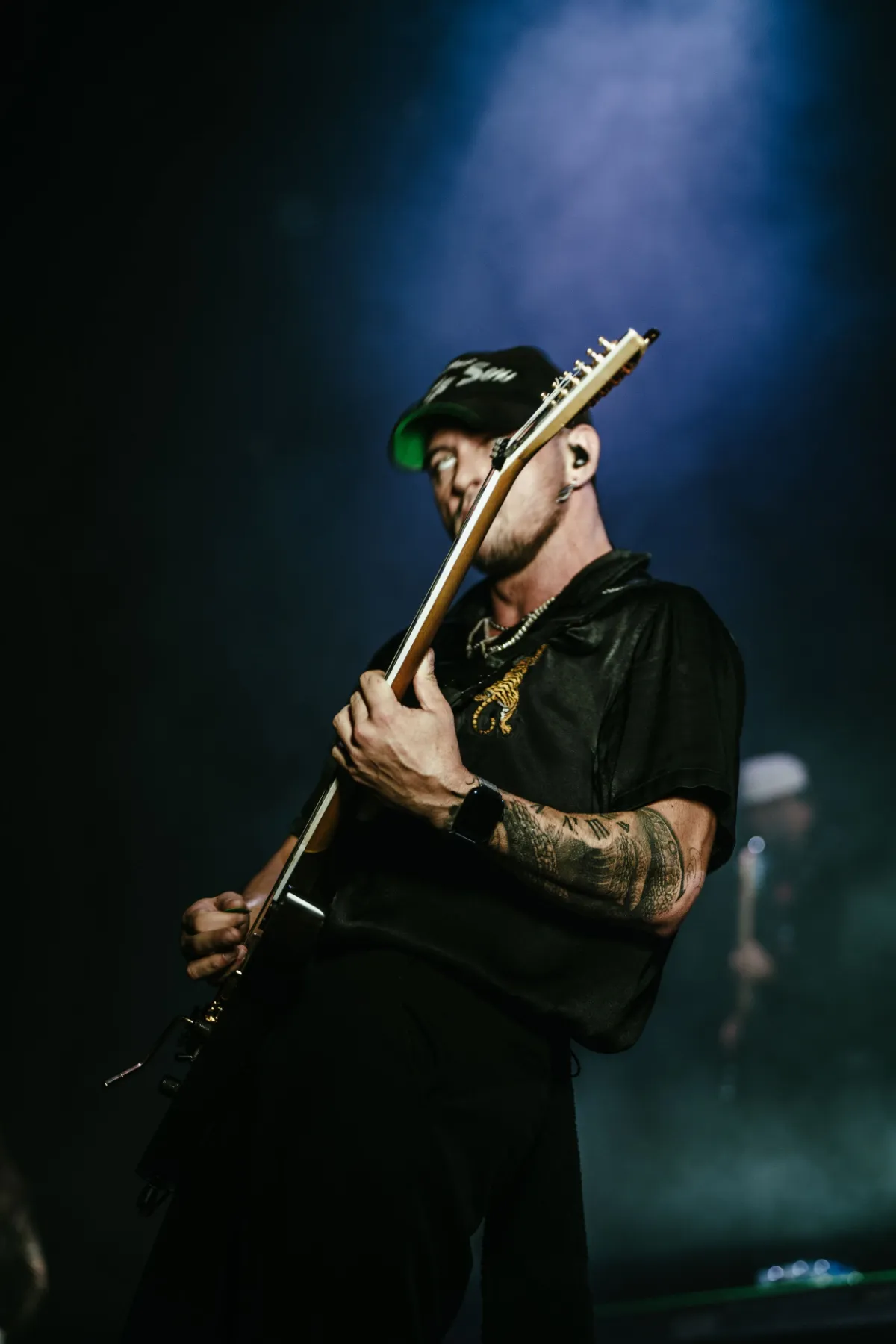 Guitariste sur scène sous lumière bleue au Théâtre Corona